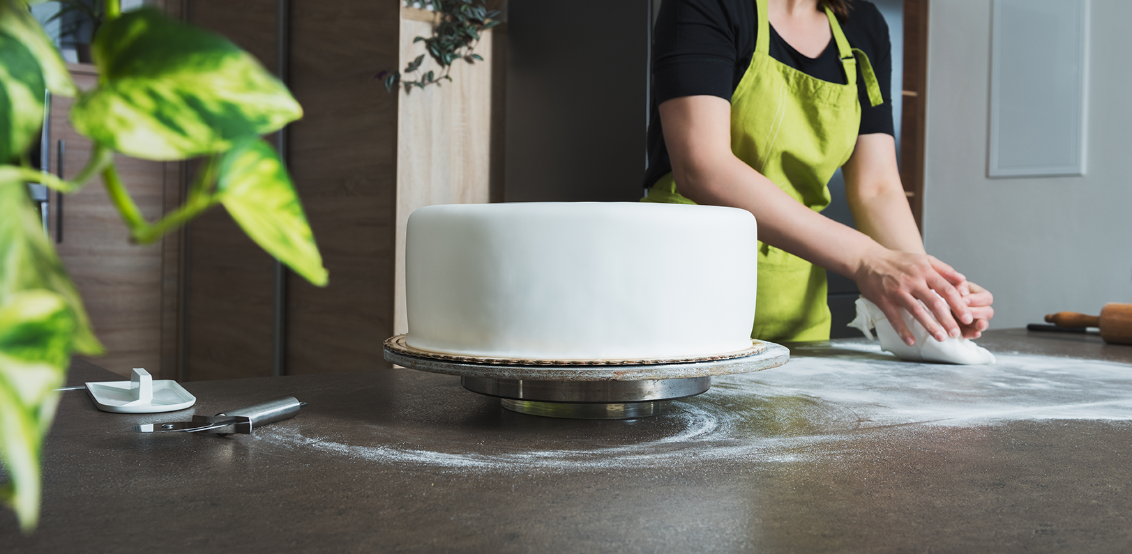 Lady icing a tiered wedding cake