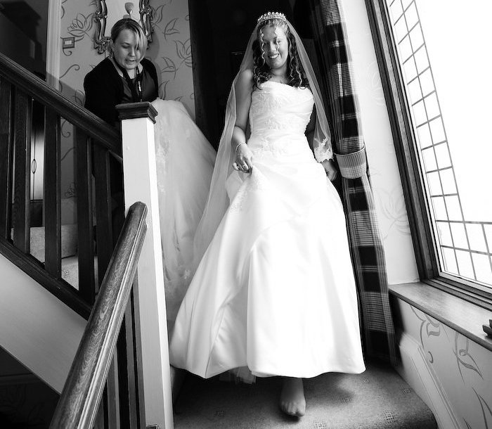 Wedding planner helping bride down the stairs